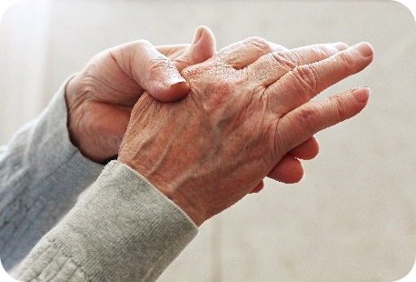an elderly person rubbing their hand.