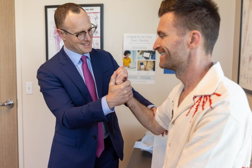 Orthopedic provider examining a smiling patient's hand and wrist strength at Proliance Puget Sound Orthopaedics